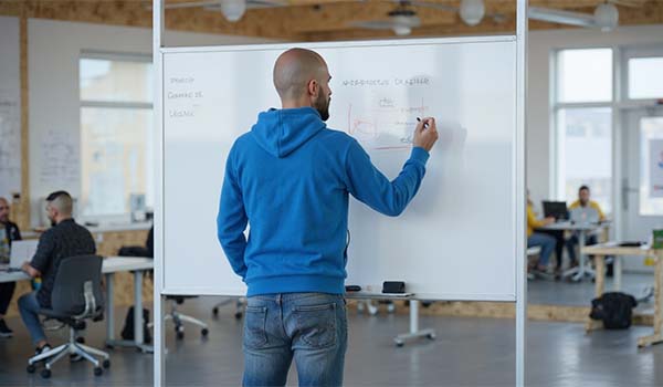 Álvaro Torres drawing a website wireframe on a whiteboard