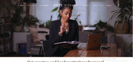 Fotografía de una mujer leyendo un libro frente a un portátil en la página de contacto de la web Boyd Visuals