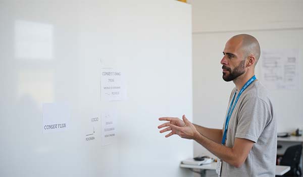 Alvaro Torres pointing to a simple diagram on a whiteboard about how consent flows on a website